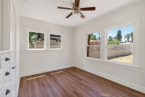 a view of empty room with wooden floor and window