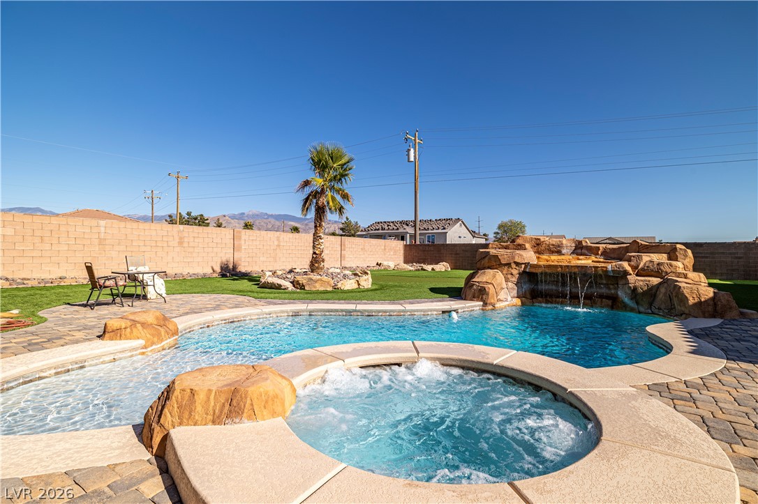2181 Winery Road Pahrump, NV 89048 - Photo 45 of 52 A tranquil backyard oasis features a free-form pool with a rock waterfall and integrated spa.