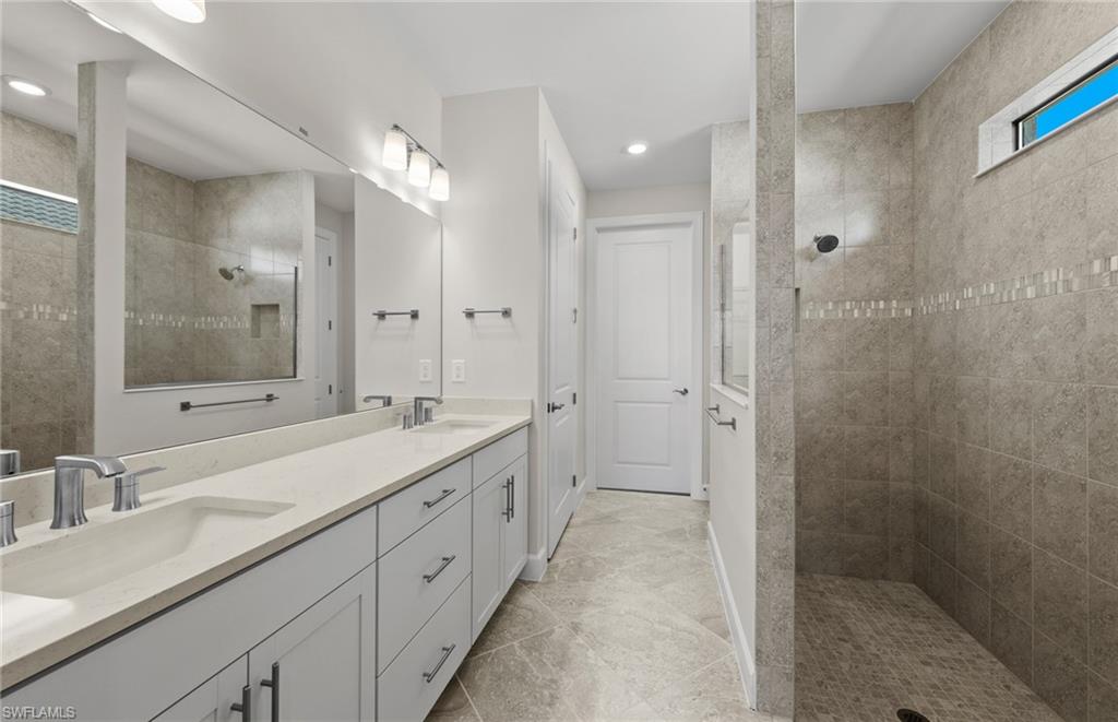 17039 Oakstead Drive Alva, FL 33920 - Photo 25 of 49 a spacious bathroom with a double vanity sink mirror double and shower