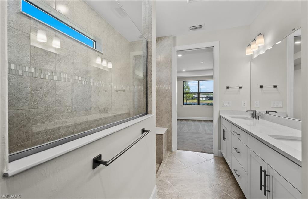 17039 Oakstead Drive Alva, FL 33920 - Photo 26 of 49 a spacious bathroom with a granite countertop sink a mirror and a shower