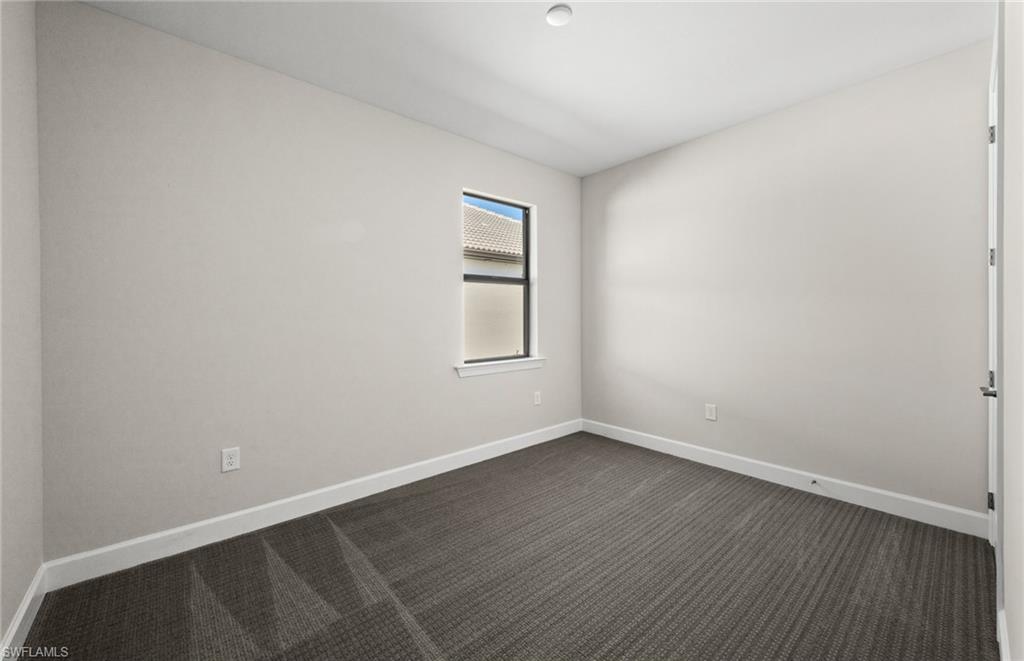 17039 Oakstead Drive Alva, FL 33920 - Photo 31 of 49 a view of an empty room with wooden floor and a window