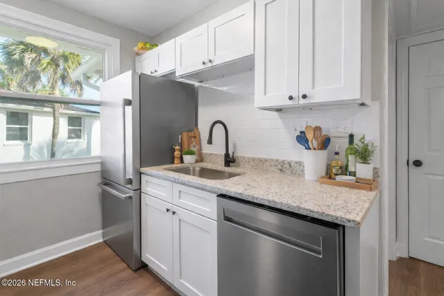 a kitchen with stainless steel appliances granite countertop a sink a stove and a refrigerator
