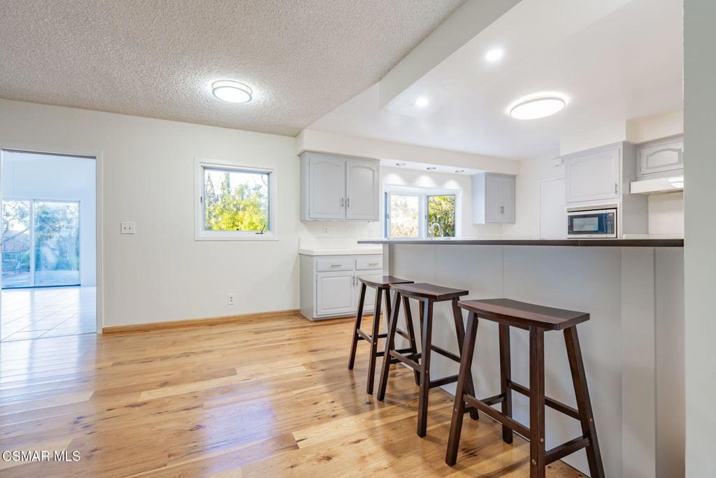 2085 Rayshire Street Thousand Oaks, CA 91362 - Photo 7 of 49 a kitchen with stainless steel appliances kitchen island a table chairs in it and wooden floor
