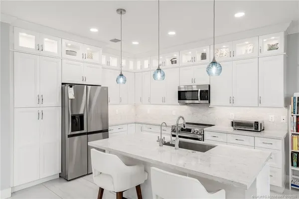 a kitchen with stainless steel appliances a refrigerator sink and microwave