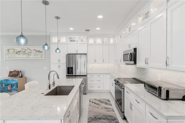 a kitchen with white cabinets and stainless steel appliances