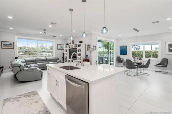 a kitchen with stainless steel appliances granite countertop a stove and a view of living room