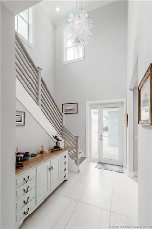 wooden floor with white cabinets and window