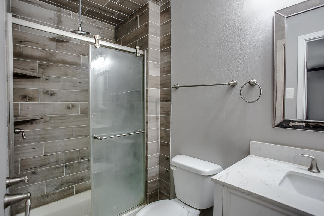 4402 28th Street Lubbock, TX 79410 - Photo 12 of 18 a bathroom with a shower toilet and sink