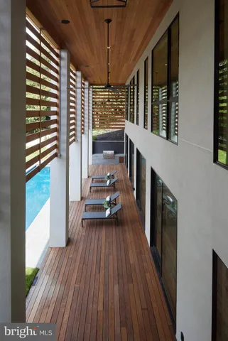 a view of a balcony with chairs and wooden floor
