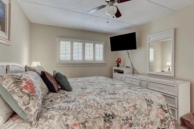 a bedroom with a bed tv and a window