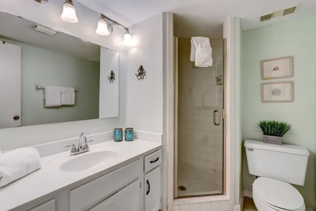 a bathroom with a granite countertop sink toilet and shower