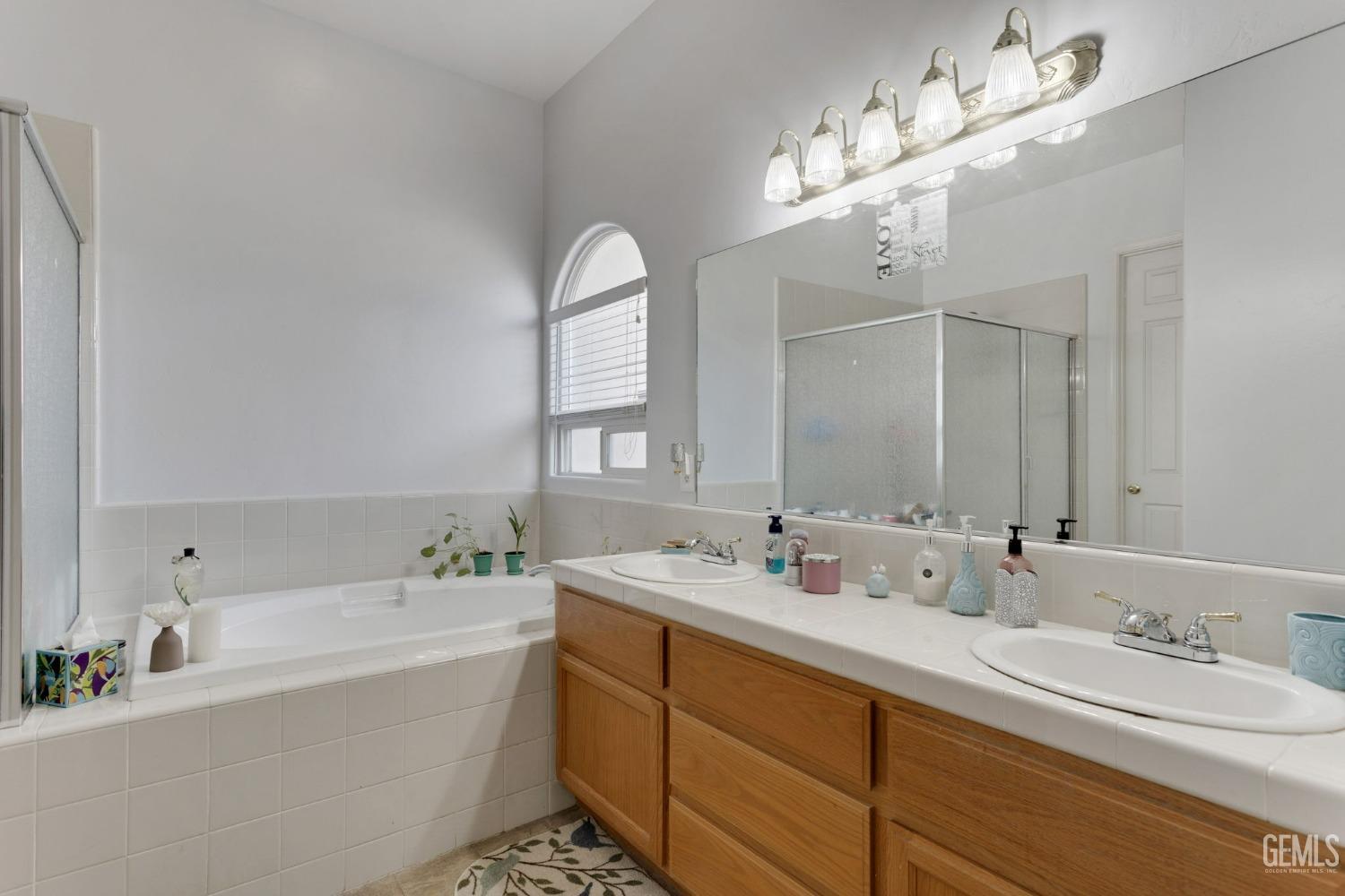 Undisclosed Address Bakersfield, CA 93314 - Photo 18 of 36 a bathroom with a tub double sink and mirror