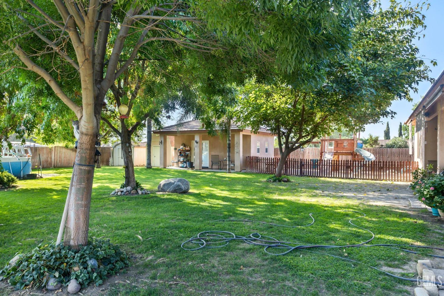 Undisclosed Address Bakersfield, CA 93314 - Photo 31 of 36 a view of a house with a yard and a large tree