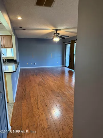 a view of empty room with wooden floor