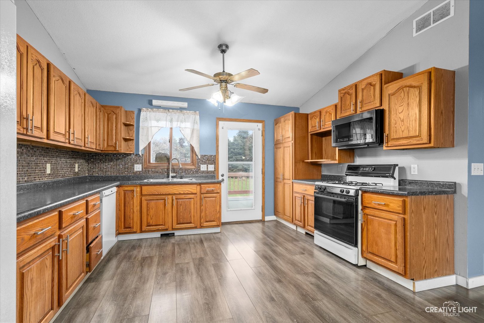 110 Windward Lane Rochelle, IL 61068 - Photo 5 of 23 a kitchen with stainless steel appliances granite countertop a stove top oven a sink dishwasher a dining table and chairs with wooden floor