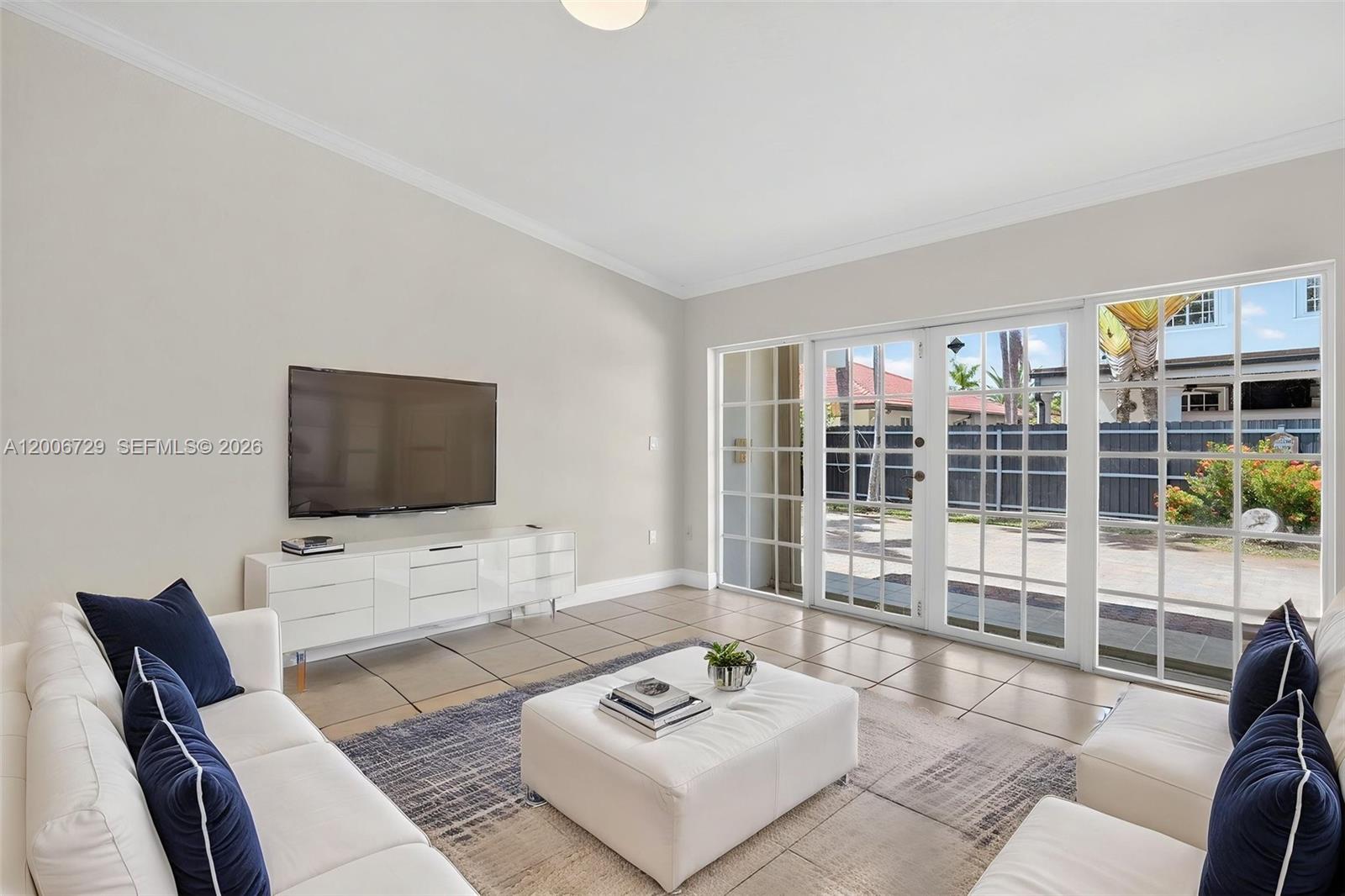 14251 Southwest 34th Street Miami, FL 33175 - Photo 13 of 54 a living room with furniture a flat screen tv and a floor to ceiling window