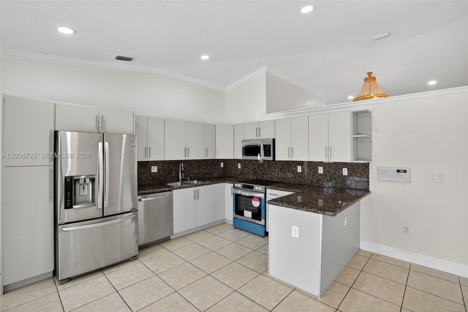 14251 Southwest 34th Street Miami, FL 33175 - Photo 15 of 54 a kitchen with stainless steel appliances and white cabinets