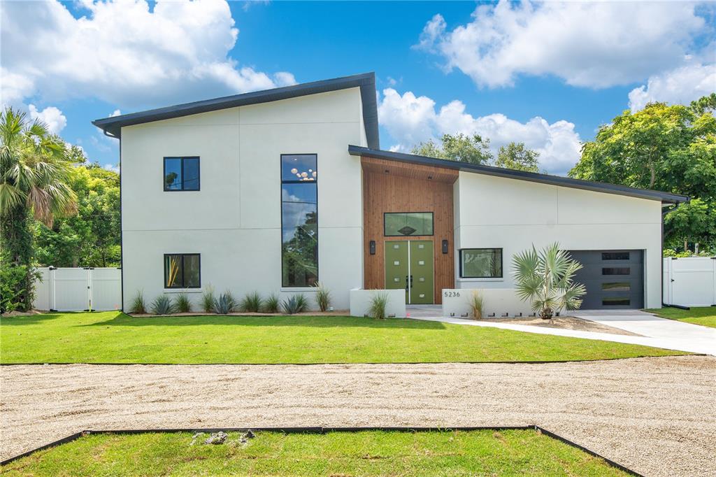 a view of a house with a yard and potted plants