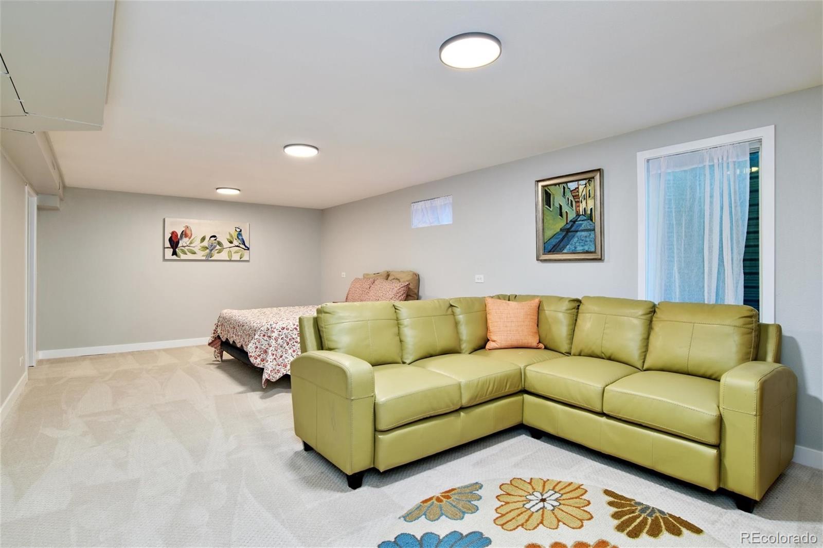 3225 Vance Street Wheat Ridge, CO 80033 - Photo 16 of 29 a blue couch sitting in a living room with a rug