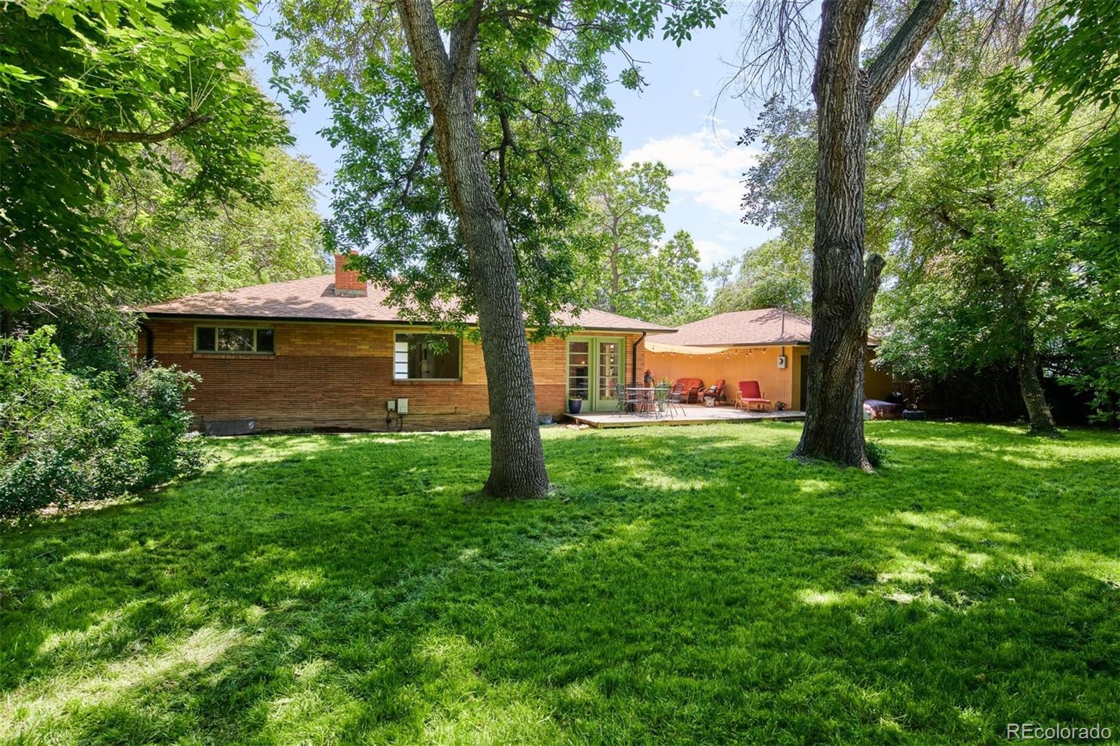 3225 Vance Street Wheat Ridge, CO 80033 - Photo 25 of 29 a view of a backyard with large trees and a barn