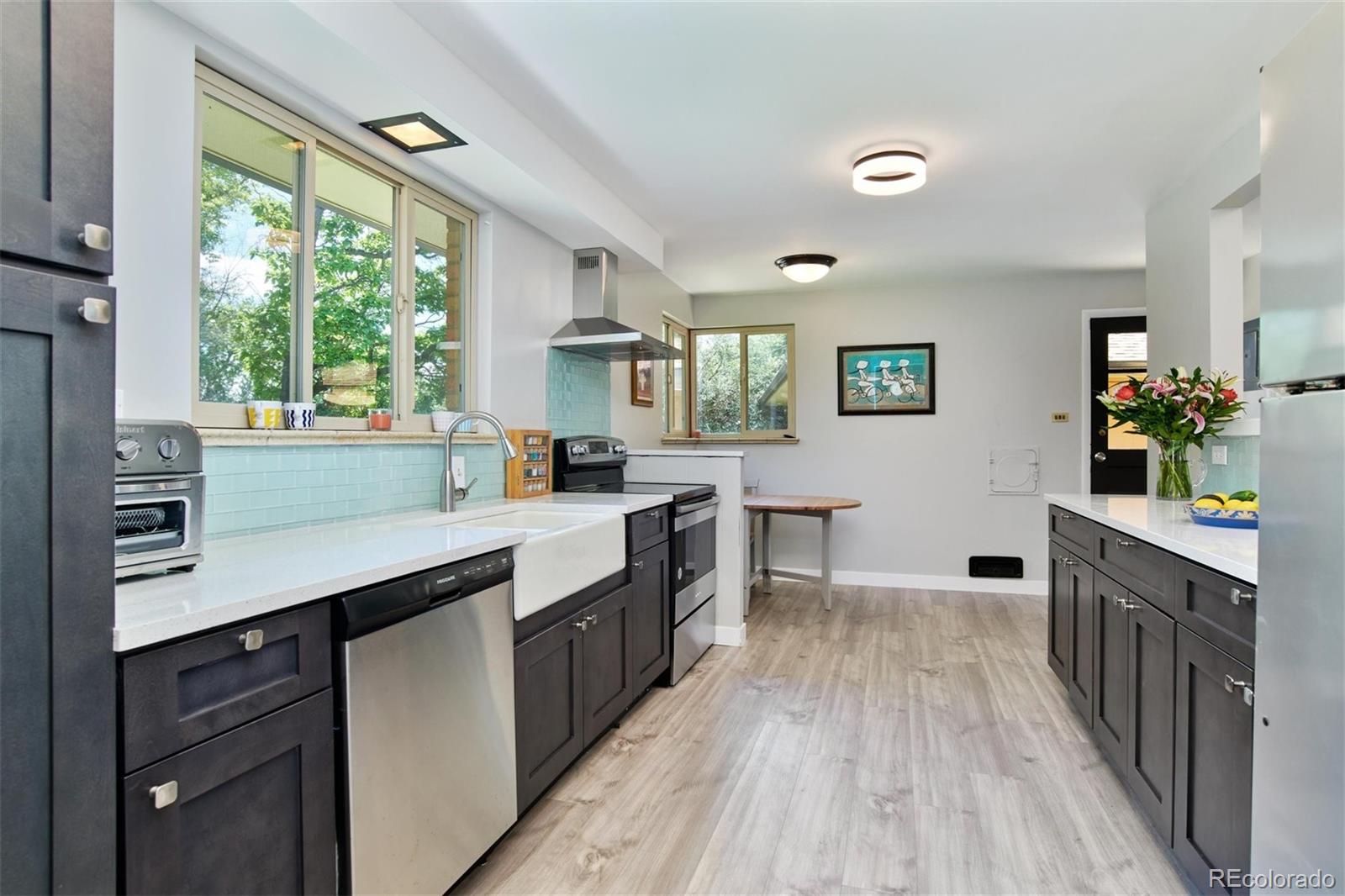 3225 Vance Street Wheat Ridge, CO 80033 - Photo 5 of 29 a kitchen with wooden floors and sink