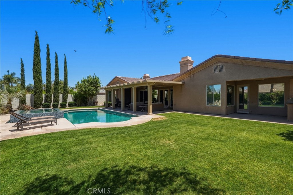 9 Orleans Road Rancho Mirage, CA 92270 - Photo 63 of 71 a view of a house with swimming pool and a yard