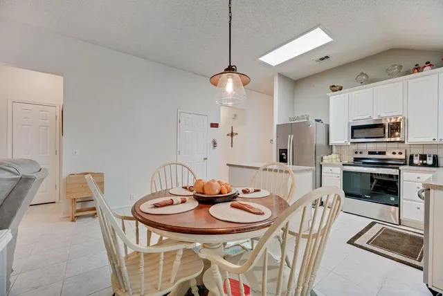a kitchen with stainless steel appliances a table and chairs