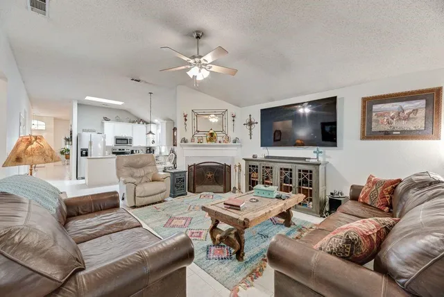 a living room with furniture a flat screen tv and a fireplace