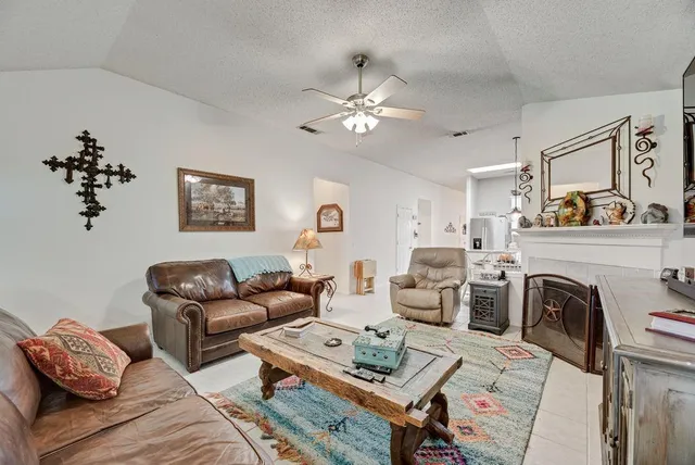 a living room with furniture a fireplace and a chandelier