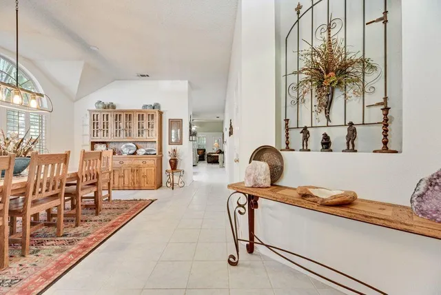 a view of a dining room and livingroom with furniture wooden floor a chandelier