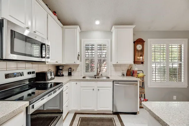 a kitchen with a sink a stove and cabinets