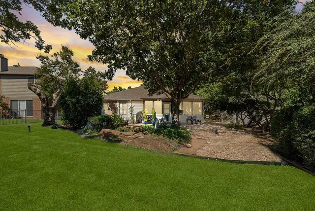 an aerial view of residential houses with outdoor space and trees
