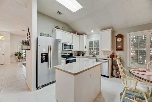 a kitchen with white cabinets and stainless steel appliances