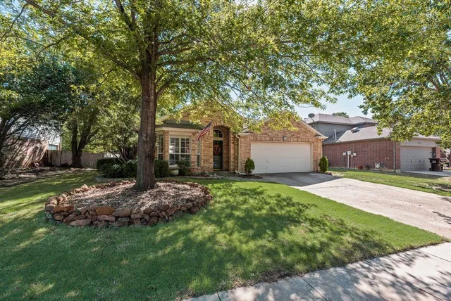 a front view of a house with a garden and trees