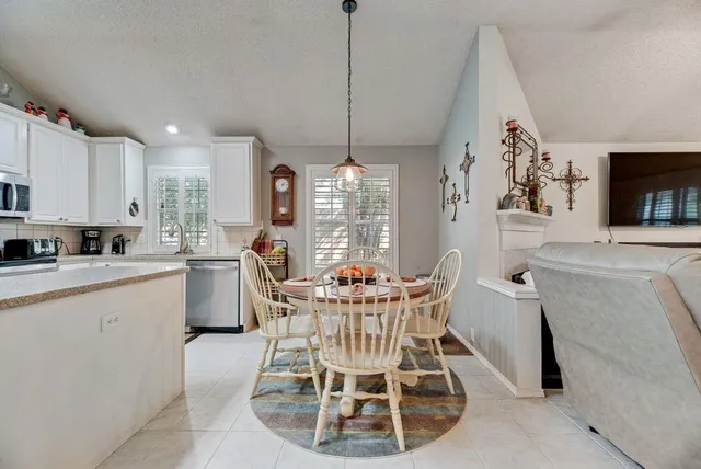 a dining room with furniture a chandelier and window