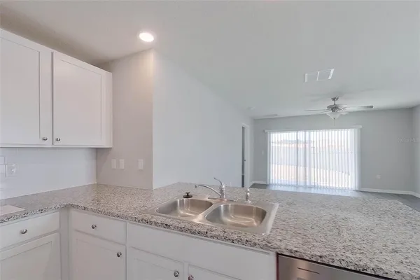 a bathroom with a granite countertop double vanity sink and mirror