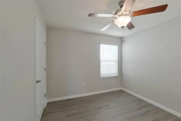 an empty room with windows and fan