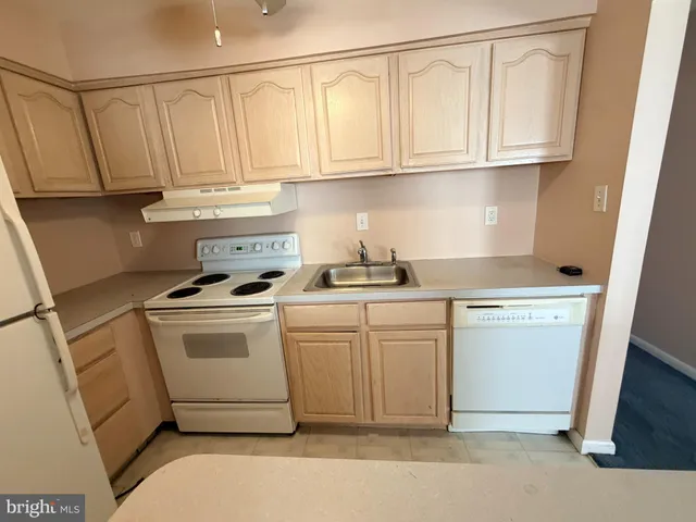 a kitchen with white cabinets and white appliances