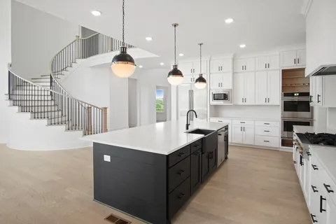 a large kitchen with a sink and a large window