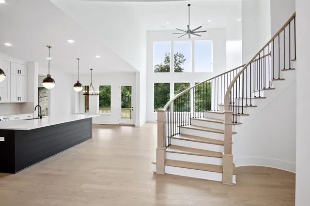 a large kitchen with kitchen island a large counter space a sink appliances and living room view