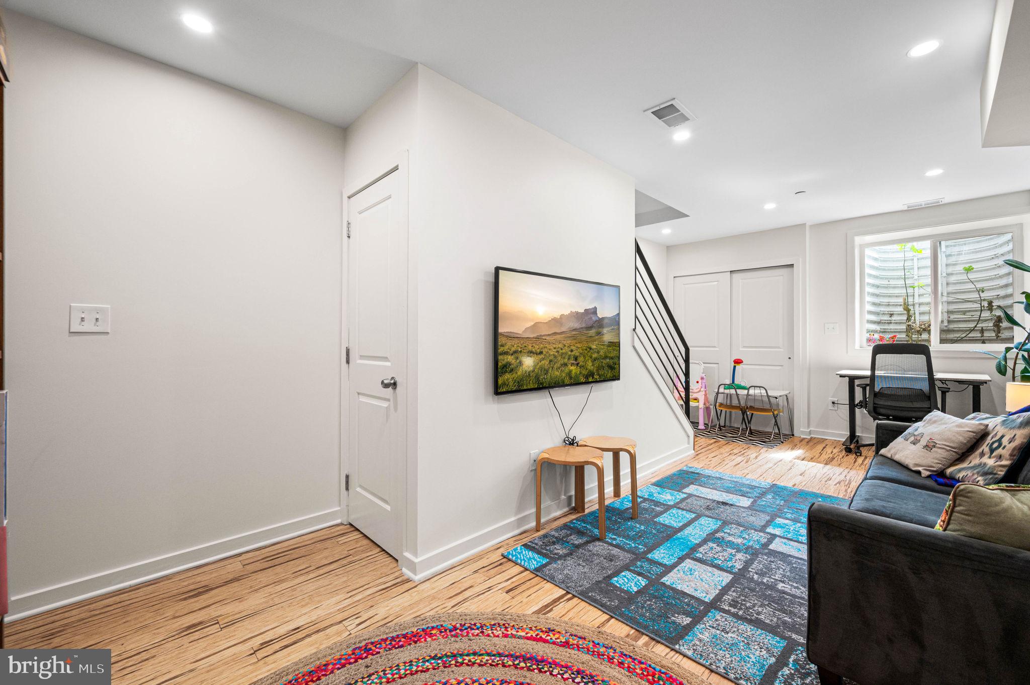 1825 Carpenter Street, Unit A Philadelphia, PA 19146 - Photo 17 of 25 a living room with furniture a flat screen tv and a large window