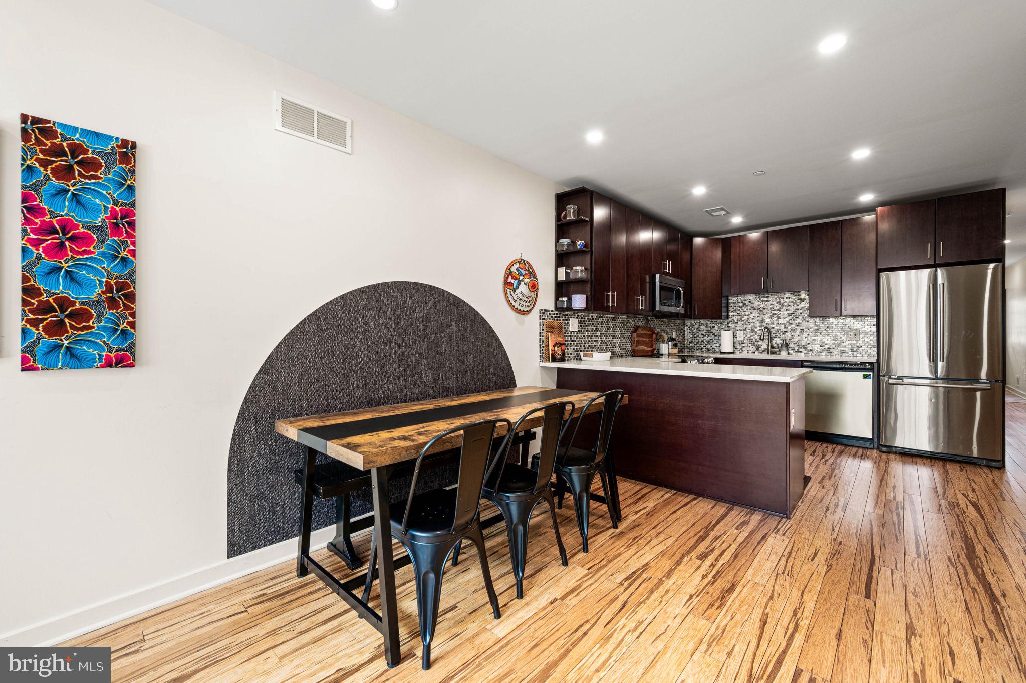 1825 Carpenter Street, Unit A Philadelphia, PA 19146 - Photo 3 of 25 a kitchen with stainless steel appliances granite countertop a dining table chairs and a refrigerator