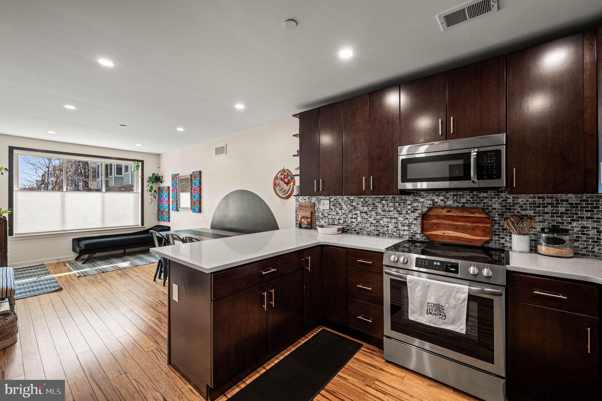 1825 Carpenter Street, Unit A Philadelphia, PA 19146 - Photo 5 of 25 a kitchen with a stove a sink and a microwave