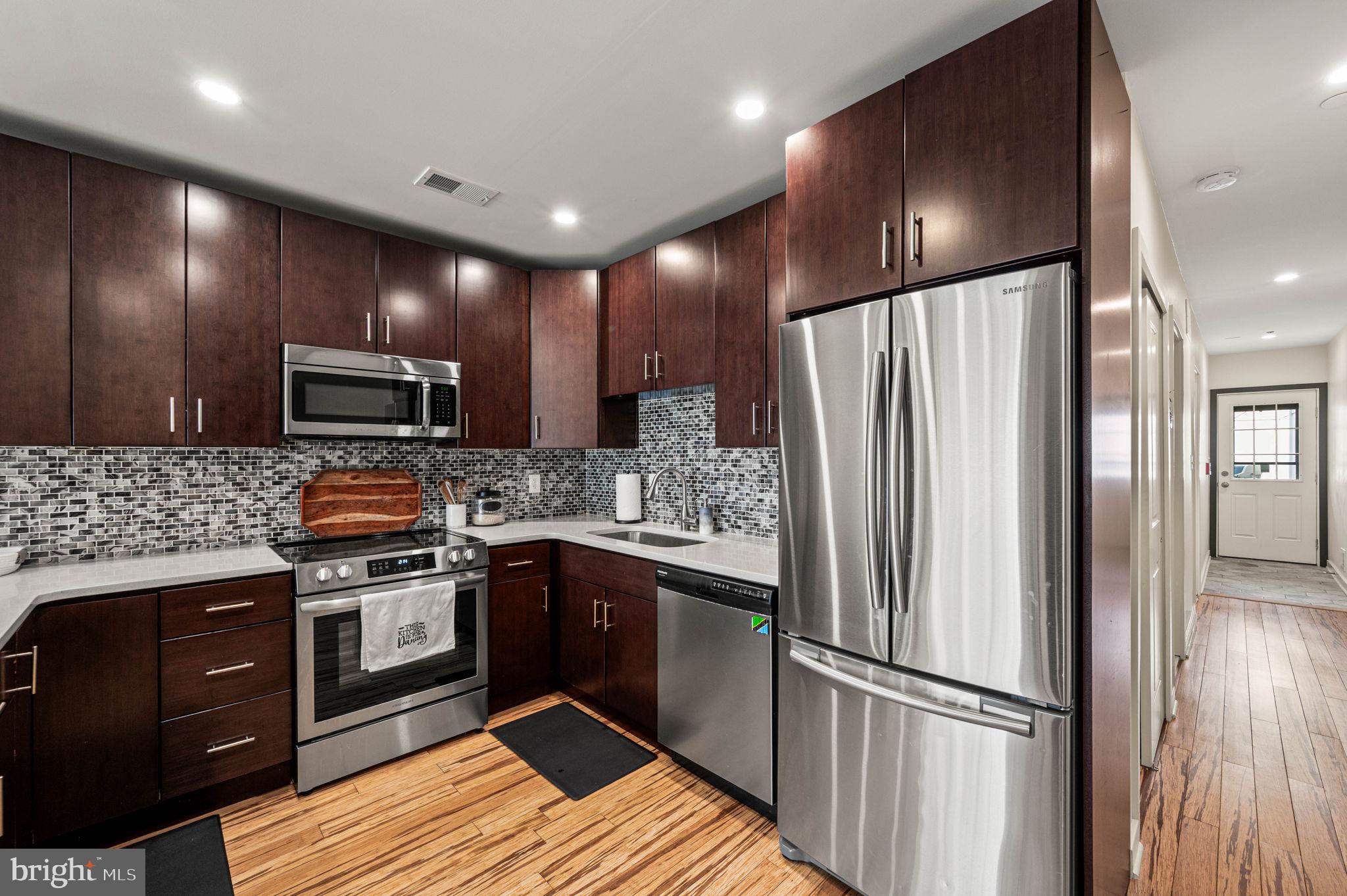 1825 Carpenter Street, Unit A Philadelphia, PA 19146 - Photo 7 of 25 a kitchen with stainless steel appliances granite countertop a refrigerator and a stove top oven