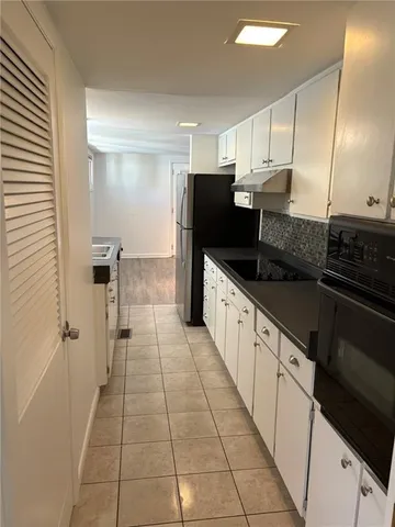 a kitchen with granite countertop a refrigerator and a sink