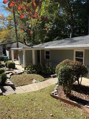 a view of a house with backyard and sitting area