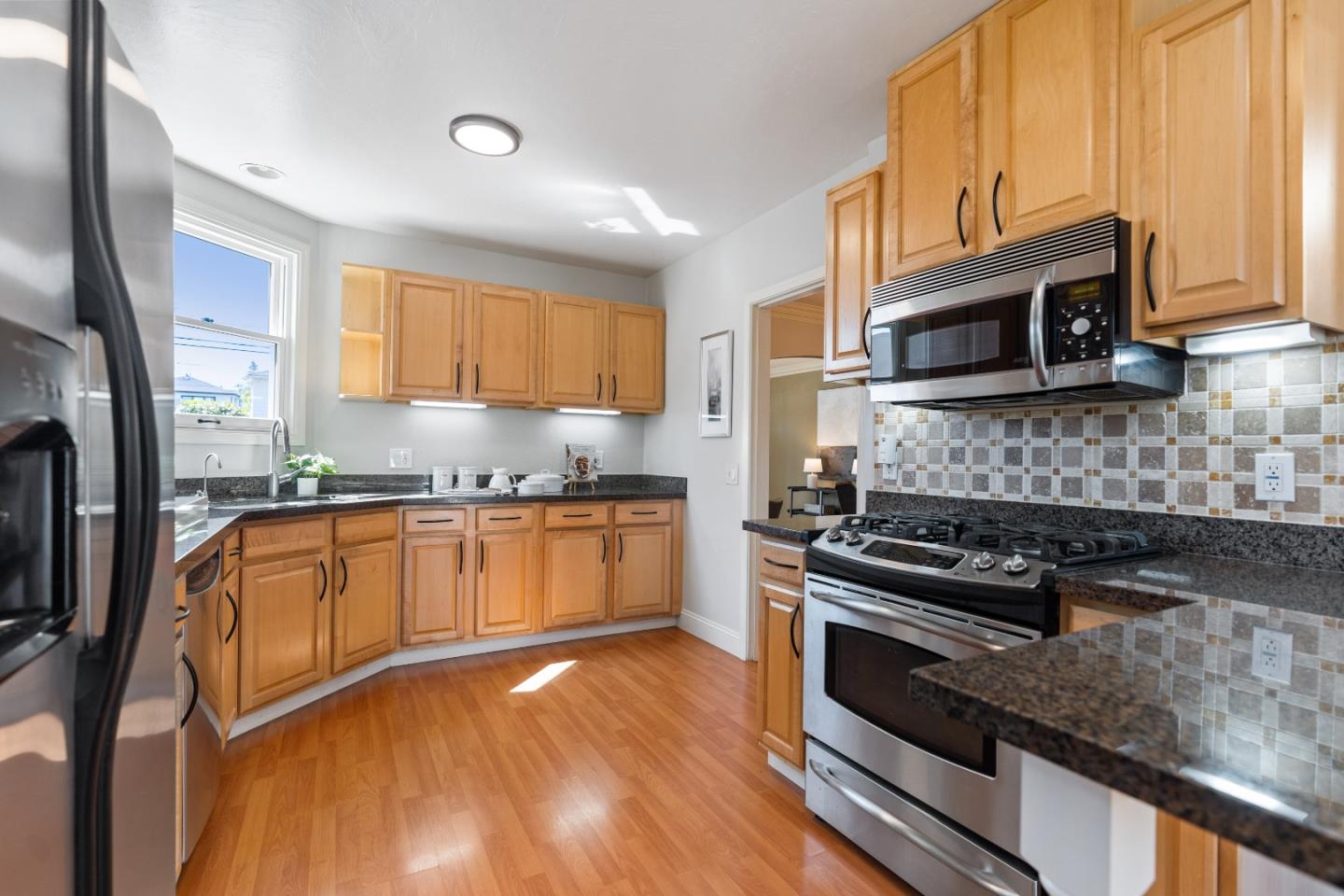 132 Bancroft Road Burlingame, CA 94010 - Photo 9 of 39 a kitchen with stainless steel appliances granite countertop a stove a sink and a microwave