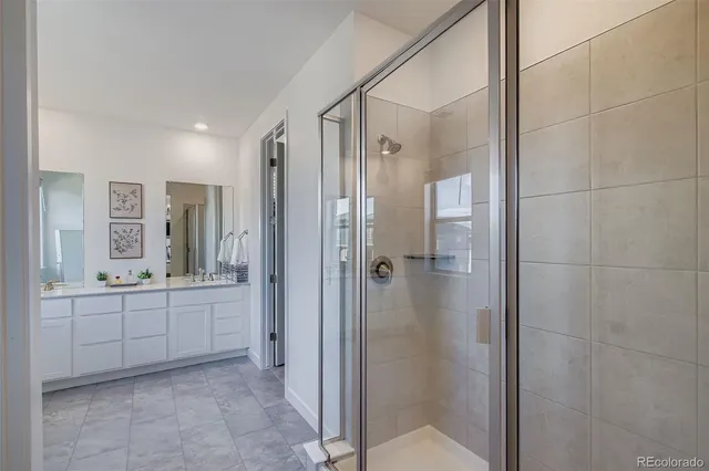 a bathroom with a glass door shower a sink and a mirror