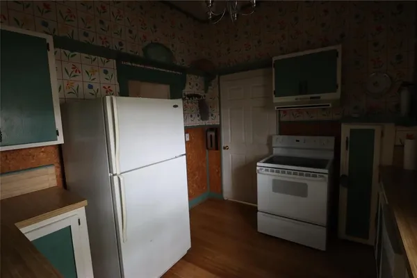 a kitchen with a refrigerator and a stove top oven