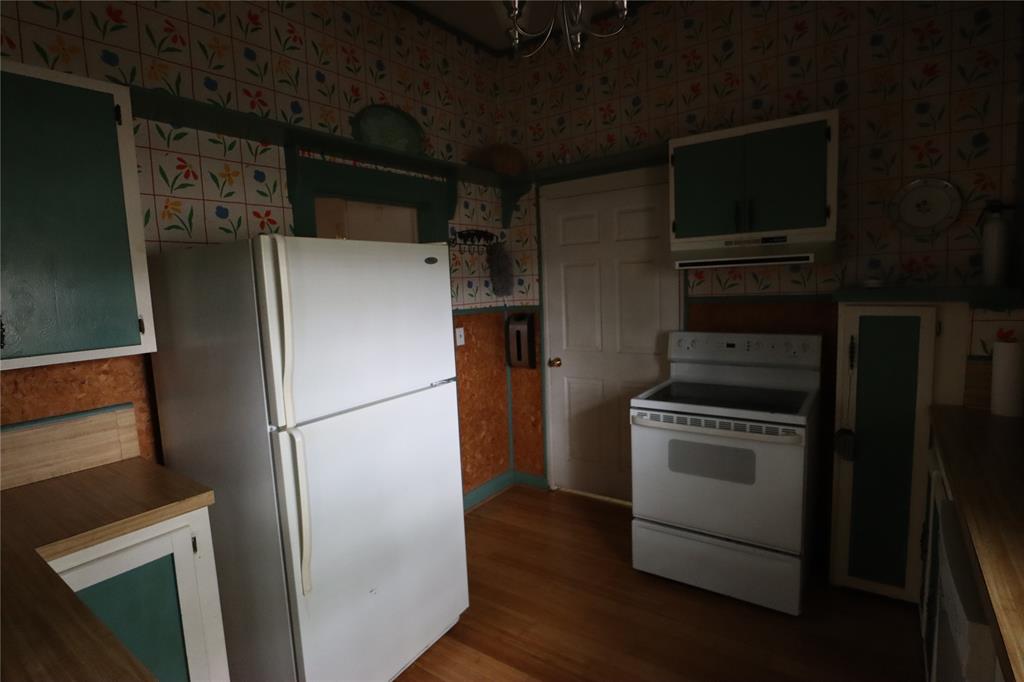 431 Walnut Street Ranger, TX 76470 - Photo 23 of 37 a white refrigerator freezer and a stove sitting inside of a kitchen